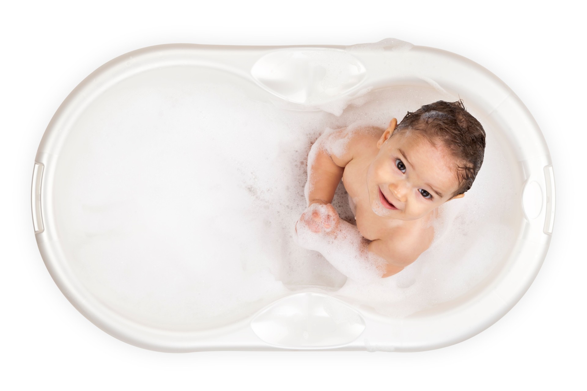 Baby in a white bathtub looking up at the camera 