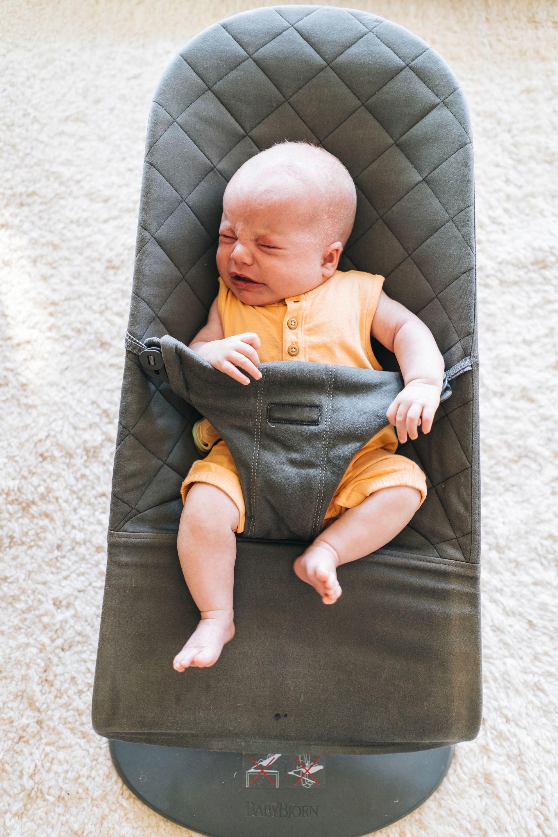 Infant boy crying in reclining chair